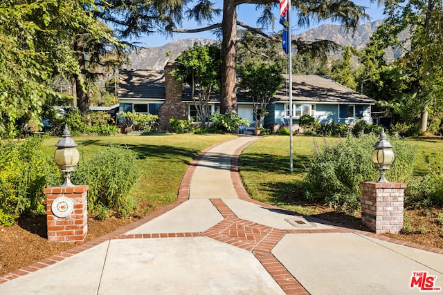 exterior space with a mountain view and a front yard