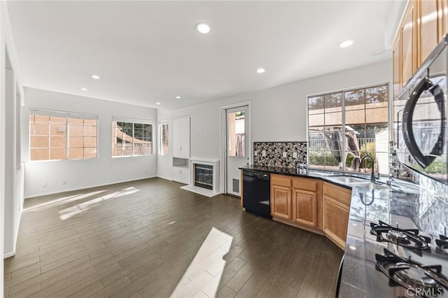 kitchen with sink, dishwasher, dark wood-type flooring, and plenty of natural light