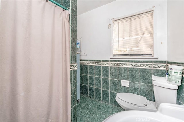 bathroom with tile walls, toilet, and walk in shower