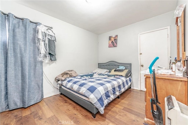 bedroom featuring radiator and hardwood / wood-style flooring