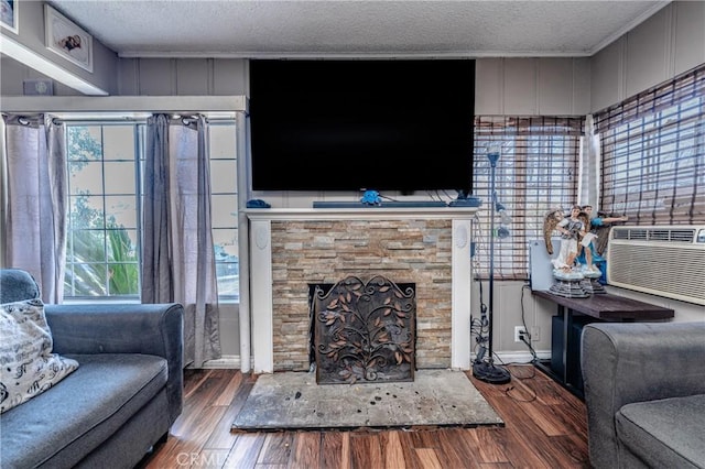 living room with cooling unit, a fireplace, a textured ceiling, and hardwood / wood-style floors