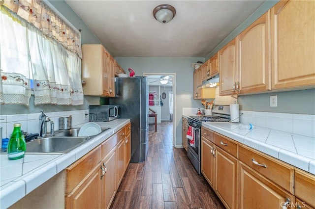 kitchen with stainless steel appliances, decorative backsplash, tile counters, dark wood-type flooring, and sink