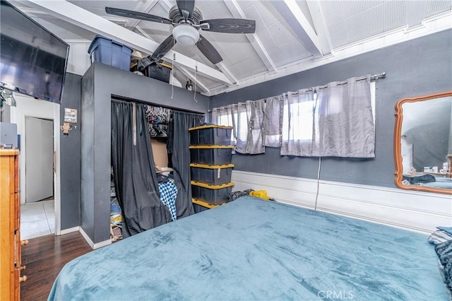 bedroom featuring ceiling fan, lofted ceiling with beams, and wood-type flooring