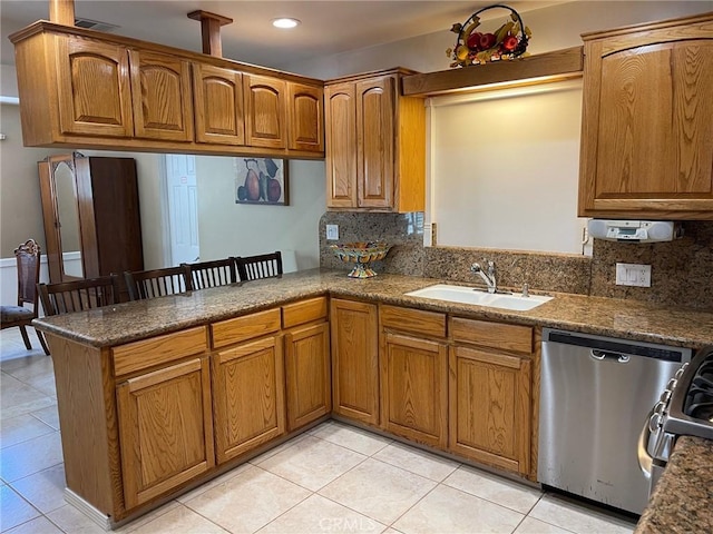 kitchen featuring tasteful backsplash, sink, stainless steel dishwasher, light tile patterned floors, and kitchen peninsula