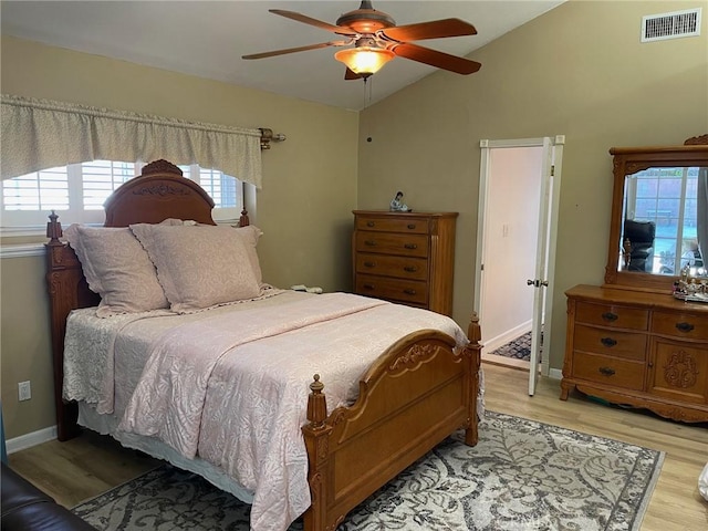 bedroom with vaulted ceiling, ceiling fan, and light wood-type flooring