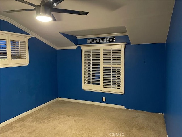 carpeted empty room featuring crown molding, ceiling fan, and lofted ceiling