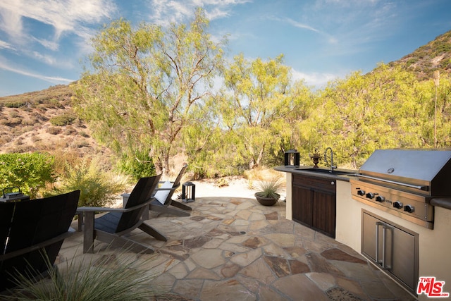 view of patio / terrace featuring exterior kitchen, sink, and a grill