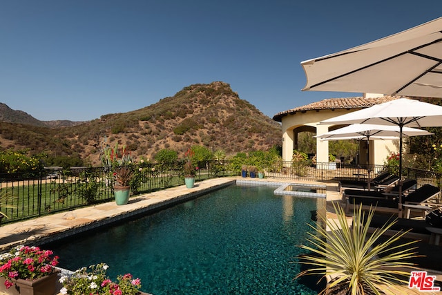 view of swimming pool featuring a mountain view and a patio