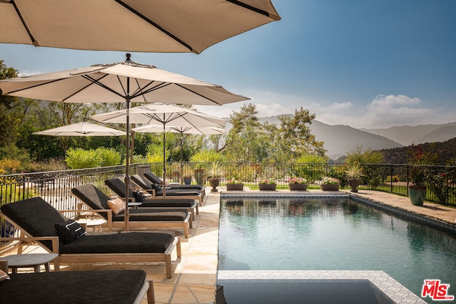 view of pool featuring a patio area and a mountain view