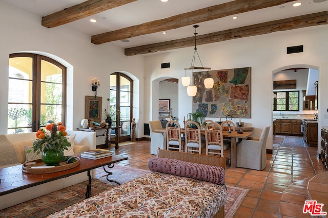 tiled living room featuring beamed ceiling and plenty of natural light