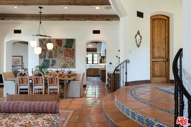 tiled dining space with beamed ceiling