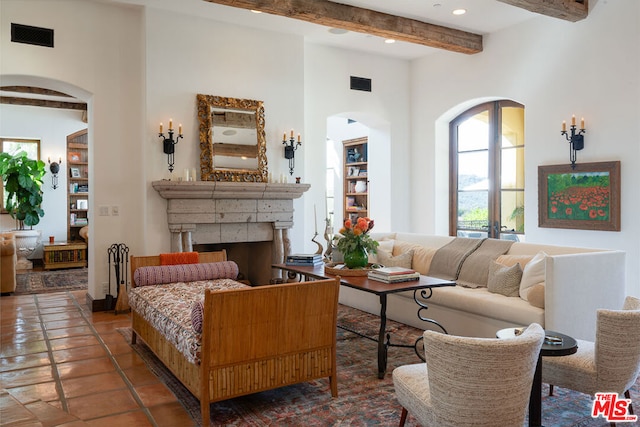 living room with beam ceiling, a high ceiling, and a fireplace