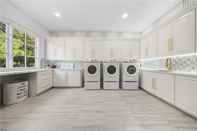 washroom featuring washer and clothes dryer, cabinets, and sink