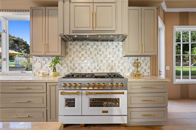 kitchen with backsplash, gray cabinets, light hardwood / wood-style flooring, and range with two ovens