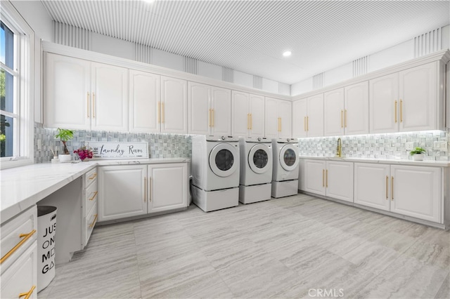 clothes washing area featuring cabinets and washer and dryer