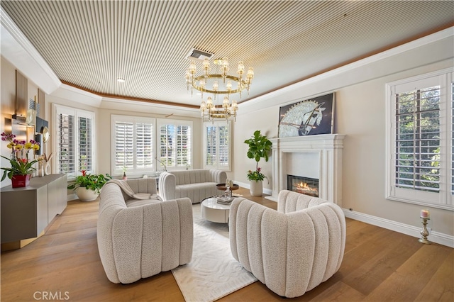 living room featuring light hardwood / wood-style flooring, crown molding, and a notable chandelier