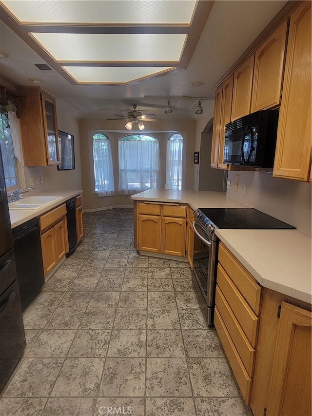 kitchen with kitchen peninsula, black appliances, sink, and ceiling fan