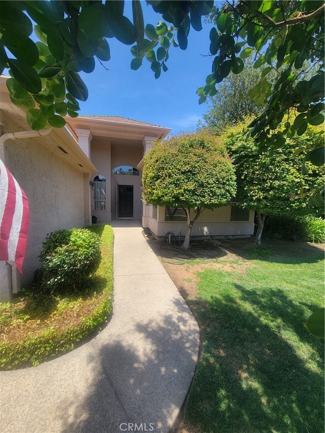 view of exterior entry featuring a yard