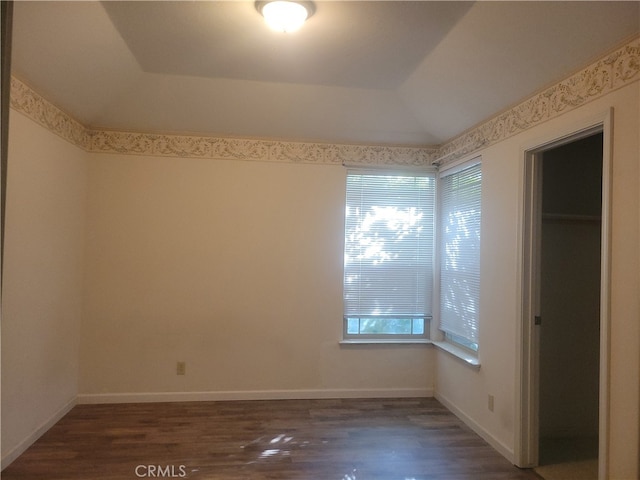 empty room featuring dark hardwood / wood-style floors and a tray ceiling