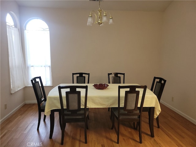 dining space with hardwood / wood-style flooring, a chandelier, and plenty of natural light