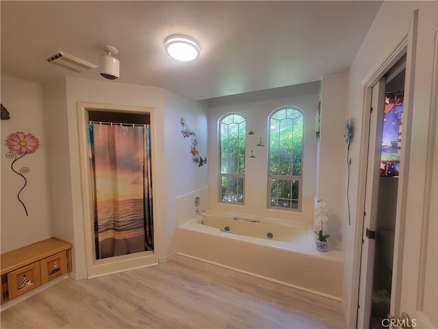 bathroom featuring separate shower and tub and hardwood / wood-style flooring