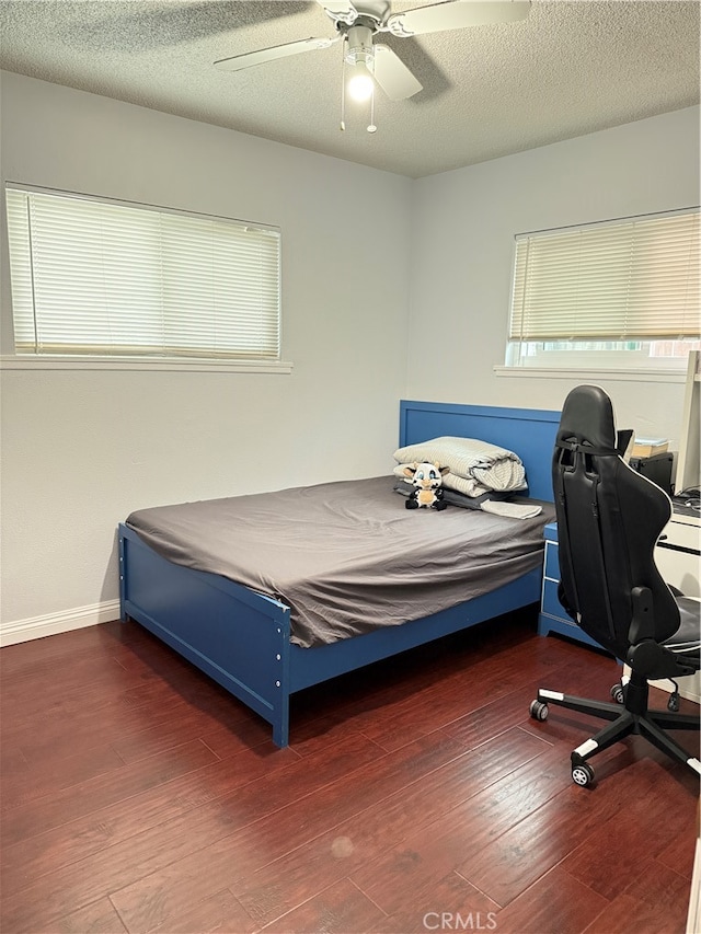 bedroom with dark hardwood / wood-style floors, a textured ceiling, and ceiling fan