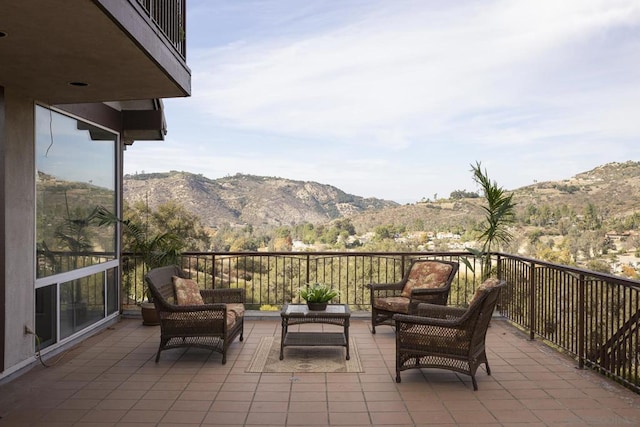 view of patio with an outdoor living space, a balcony, and a mountain view