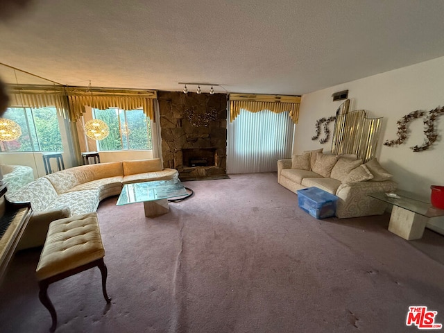 carpeted living room with a fireplace, a textured ceiling, and track lighting