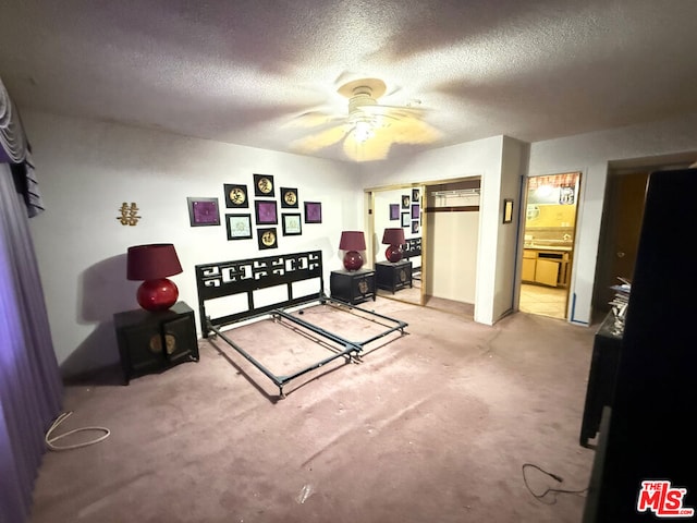 bedroom featuring ceiling fan, light colored carpet, and a textured ceiling