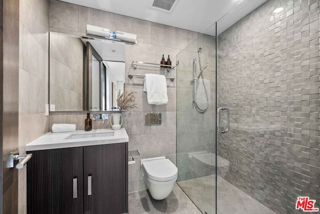 bathroom featuring vanity, tile patterned flooring, toilet, tile walls, and a shower with shower door