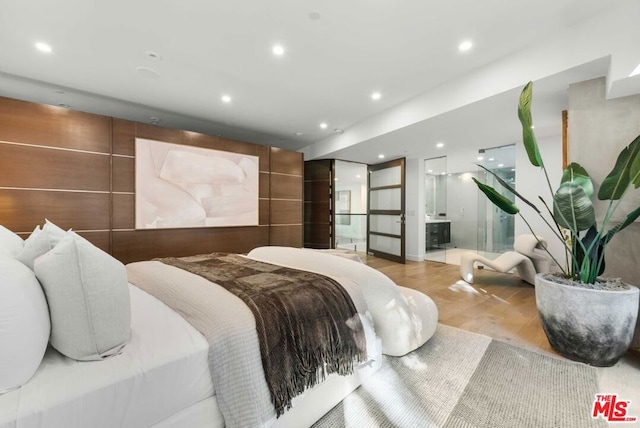 bedroom with light hardwood / wood-style floors and ensuite bath