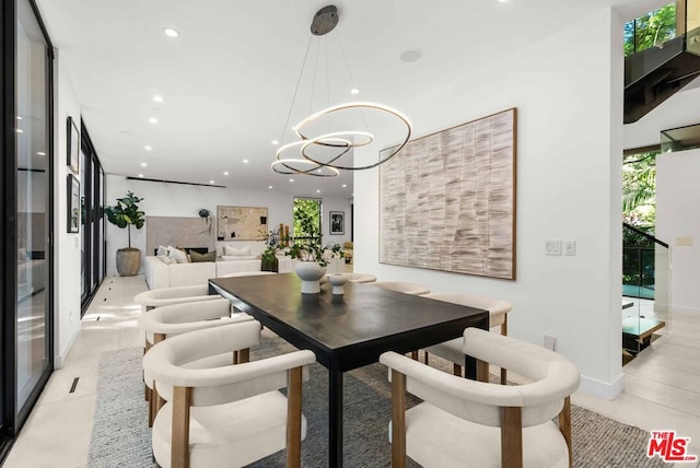 dining area with light tile patterned floors and an inviting chandelier