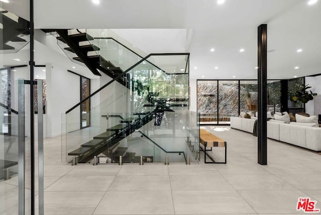 stairs featuring tile patterned flooring and expansive windows