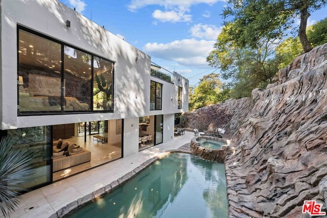 view of pool with an in ground hot tub and a patio area