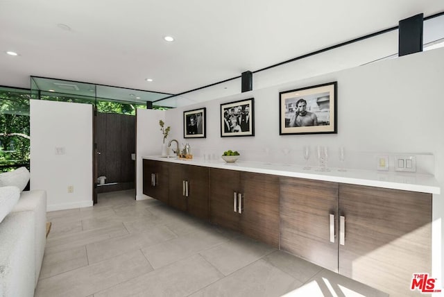 kitchen with sink, dark brown cabinets, plenty of natural light, and a wall of windows