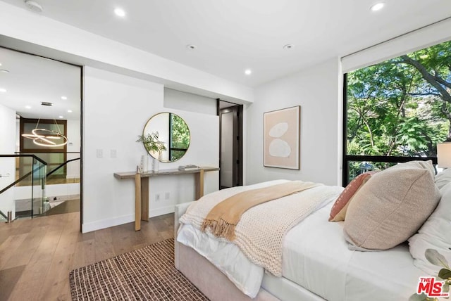 bedroom featuring wood-type flooring and multiple windows