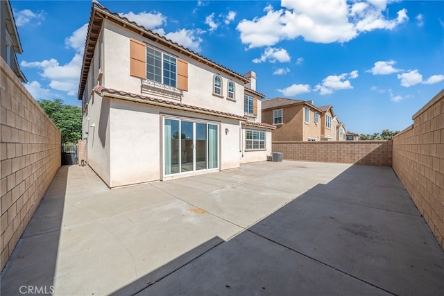 rear view of house featuring central air condition unit and a patio area