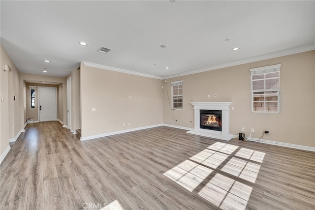 unfurnished living room featuring light hardwood / wood-style floors and crown molding