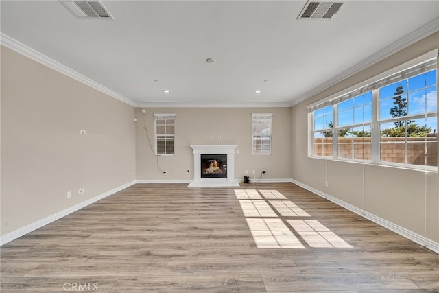 unfurnished living room with ornamental molding and light wood-type flooring