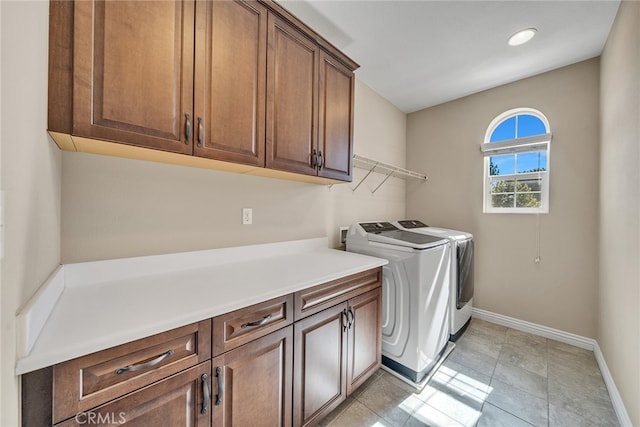 washroom featuring cabinets, washer and clothes dryer, and light tile patterned floors