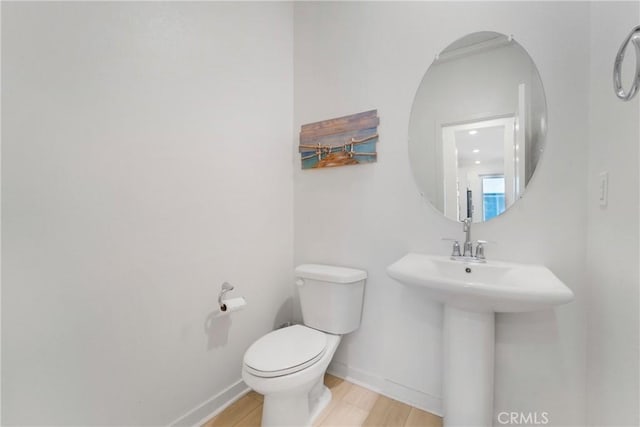 bathroom featuring hardwood / wood-style flooring, toilet, and sink