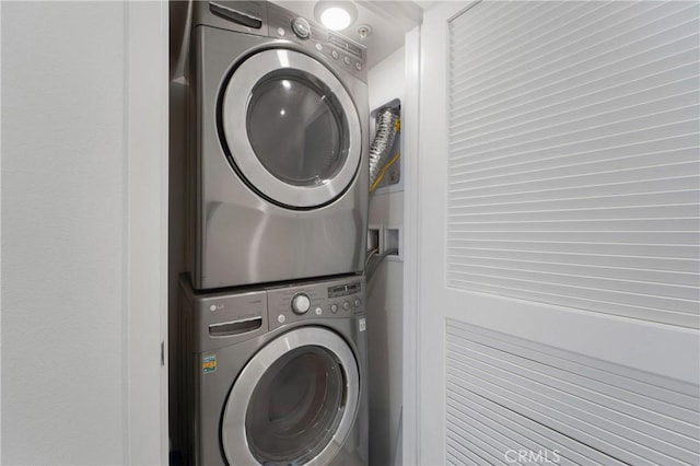 clothes washing area with stacked washer / dryer