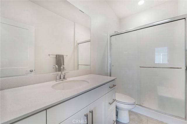 bathroom featuring tile patterned flooring, vanity, toilet, and a shower with door