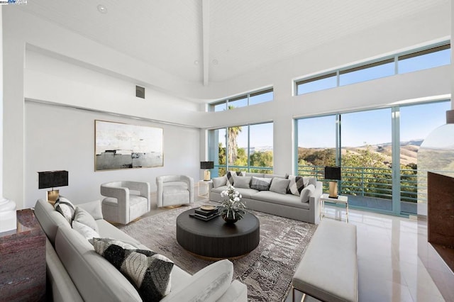 living room with tile patterned flooring and a high ceiling