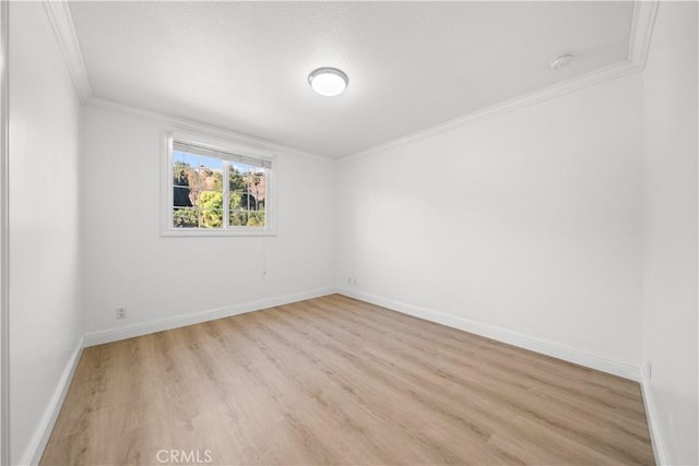 empty room featuring crown molding and light wood-type flooring