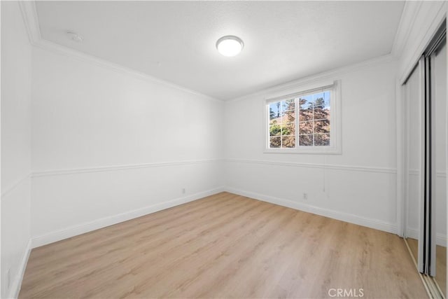 unfurnished bedroom with a closet, light hardwood / wood-style flooring, and ornamental molding