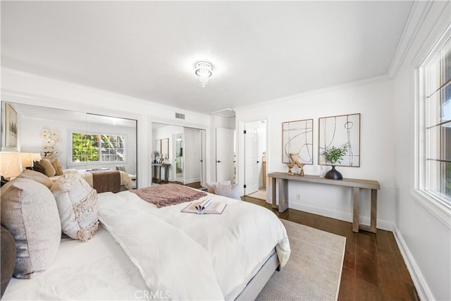 bedroom with crown molding, dark wood-type flooring, and connected bathroom