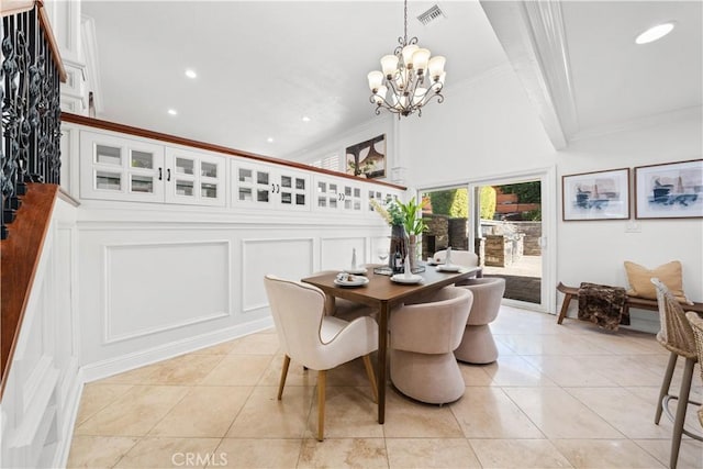 tiled dining area featuring an inviting chandelier and crown molding