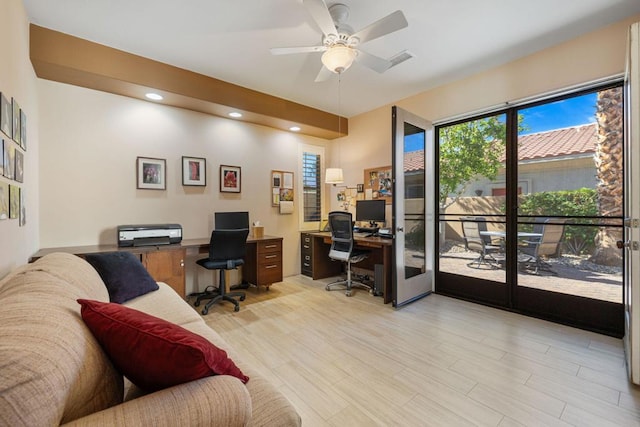 home office with ceiling fan and light hardwood / wood-style flooring