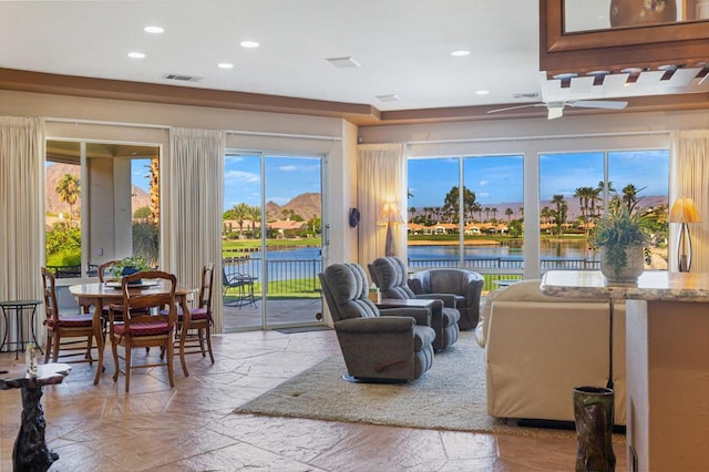 living room featuring a water view and ceiling fan